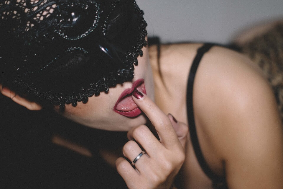 Lady with black lace mask. Pointing to her half open lips